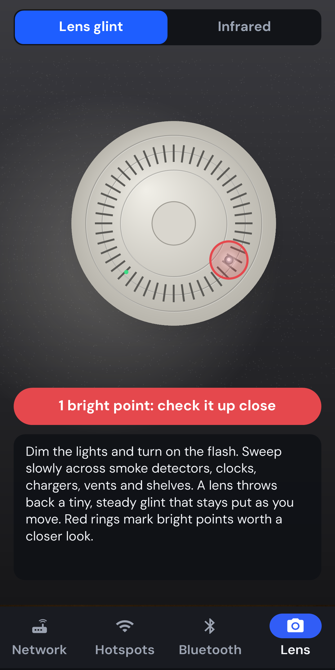 The Lens finder's camera preview with a red ring around the glinting pinhole lens on a smoke detector and the message 1 bright point: check it up close